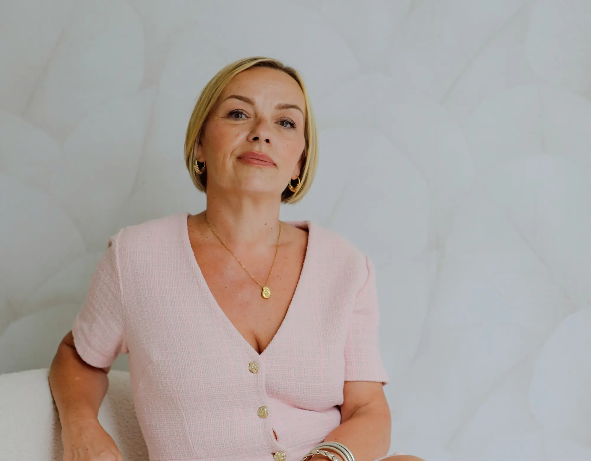 Stéphanie Bariant, assise sur un canapé blanc